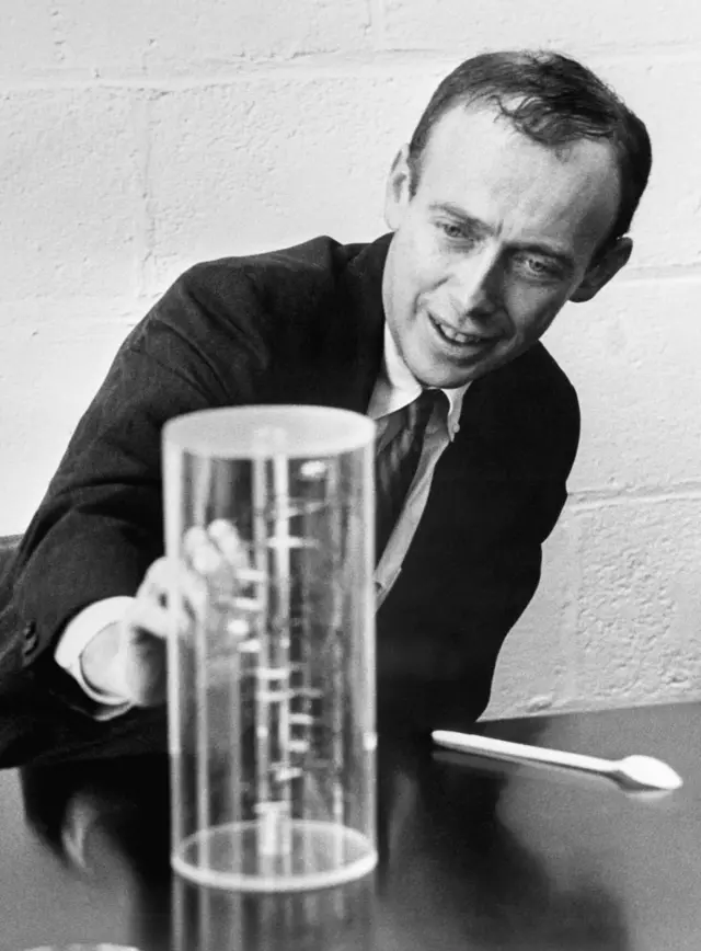 James Watson muestra un modelo de ADN en su laboratorio.