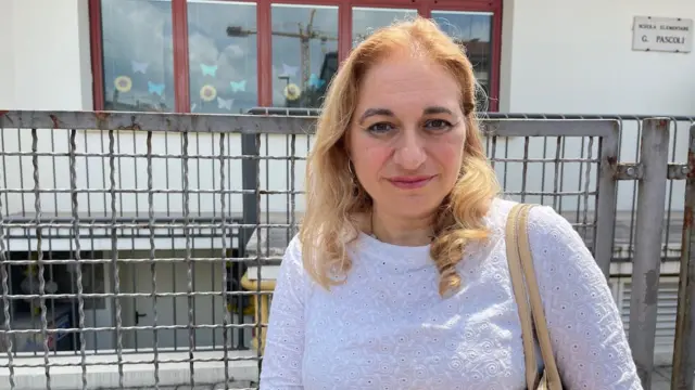 La rectora Luana Scarfi, una mujer rubia con un suéter blanco