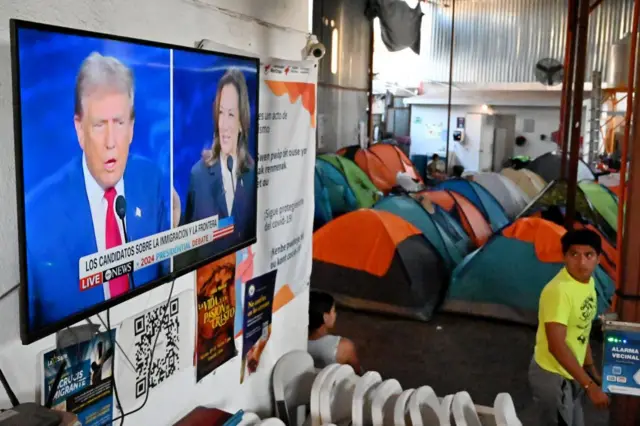 Televisión con el debate electoral en un campamento de migrantes