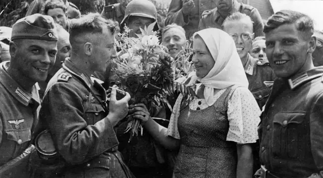 Soldados alemanes son recibidos con flores en un pueblo ucraniano