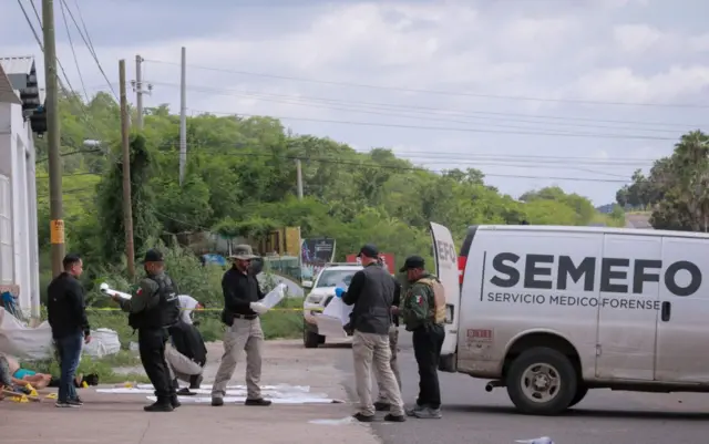 Trabajadores forenses junto a cuerpos sin vida en Culiacán