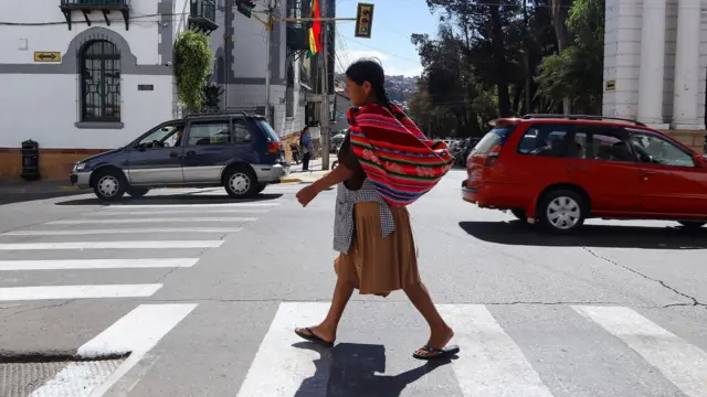 Un mujer camina por la calle en Bolivia.