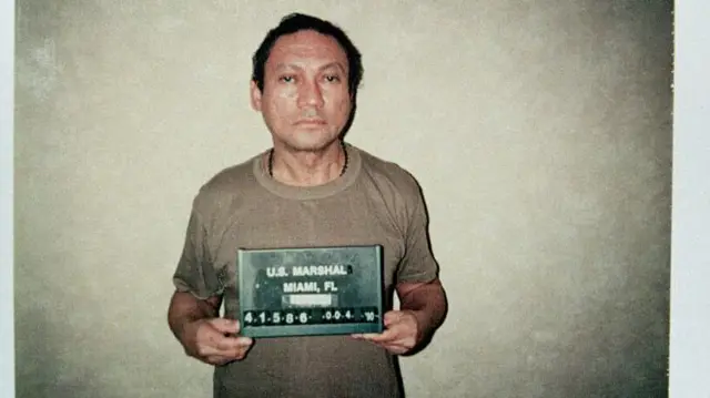 Noriega, con semblante triste, posa en camiseta para la foto en una imagen típica de las fichas policiales. 