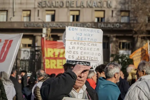 Un hombre sostiene un cartel contra el hambre y la pobreza durante la Marcha de los Jubilados frente al Congreso Nacional en Buenos Aires, Argentina, el 30 de julio.