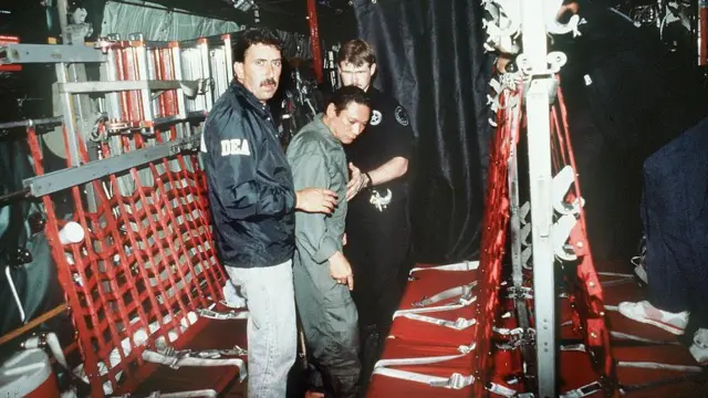 El general panameño derrocado Manuel Noriega es trasladado a un avión militar estadounidense el 3 de enero de 1990 para un vuelo a Miami tras su arresto. 