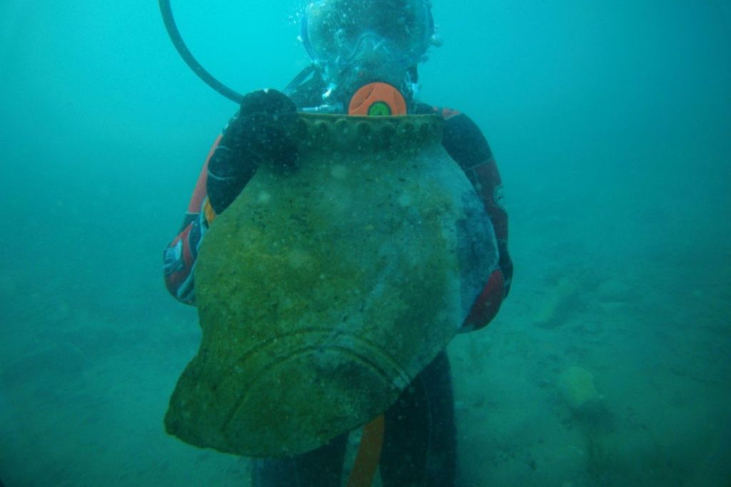 Un miembro del equipo del Instituto de Arqueología de la Academia Rusa de Ciencias sostiene un fragmento de una gran vasija recuperada en uno de los yacimientos sumergidos