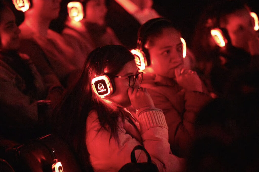 Asistente a la puesta en escena El episodio maldito usando audífonos.
