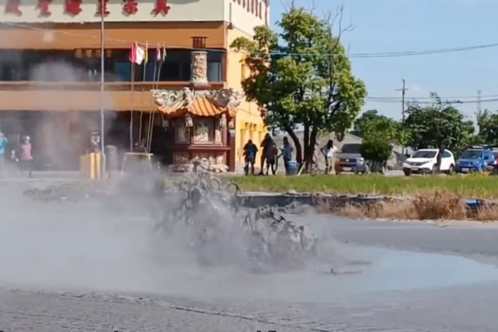 Un grupo de curiosos se reúne junto al templo Huangyuan para observar la erupción del volcán de barro