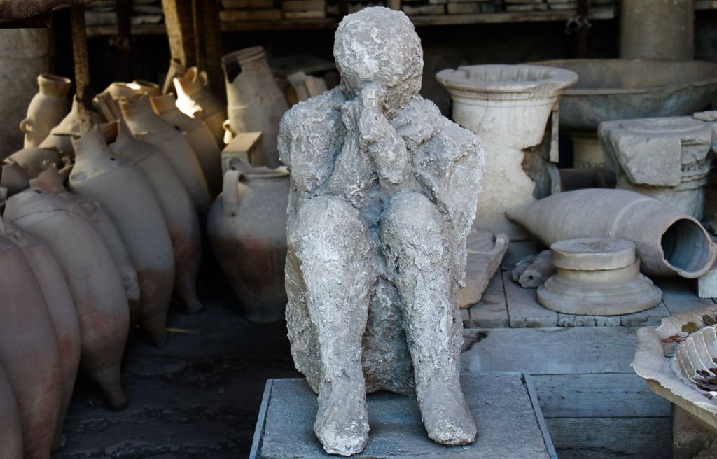 Ánforas y huella de figura humana petrificada en Pompeya 