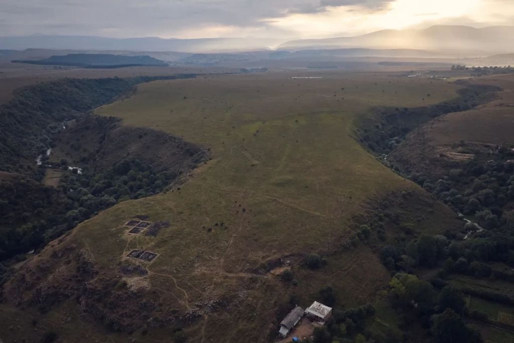 Fotografía al atardecer del sitio, ubicado en la confluencia de dos profundas gargantas. En primer plano se pueden observar las excavaciones realizadas en 2023 en el interior de la fortaleza