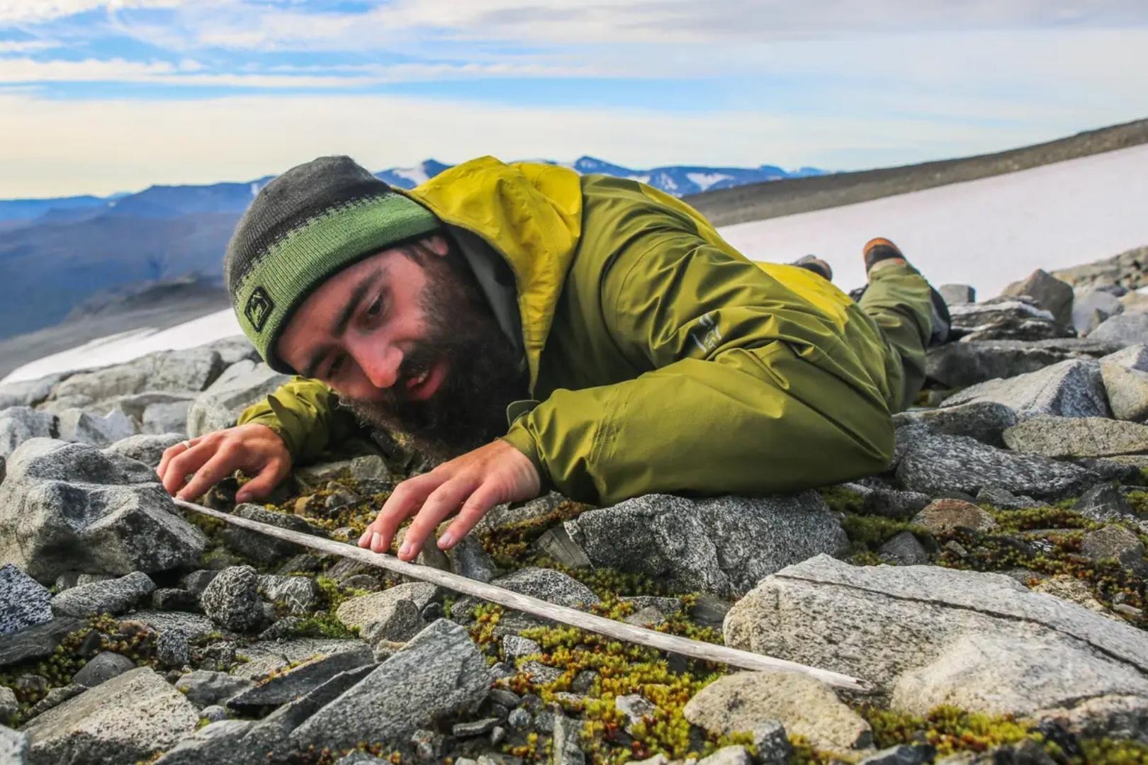 Un miembro del equipo observa con atención un asta de flecha perfectamente conservada por el hielo