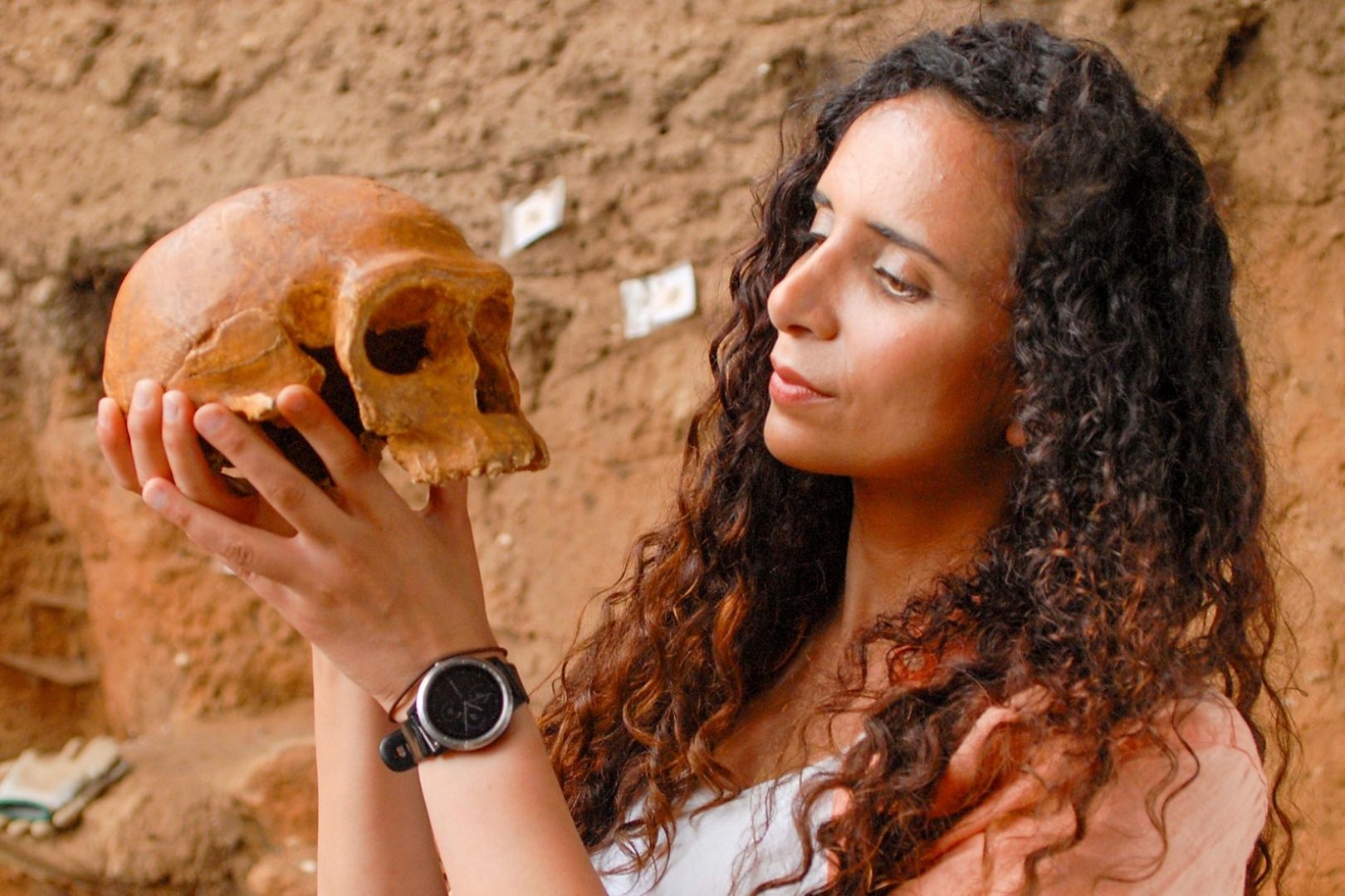 La paleoantropóloga Ella Al-Shamahi examina con atención una réplica del cráneo de Irhoud 1