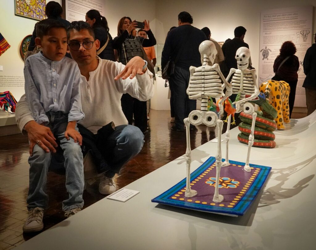 Padre explicándole a su hijo una escultura del Museo de Arte Popular.
