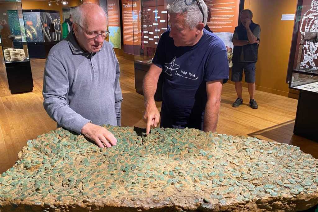 Los buscadores de tesoros Reg Mead (izquierda) y Richard Miles (derecha) observan una réplica del tesoro Le Câtillon II, expuesta en el Museo La Hougue Bie