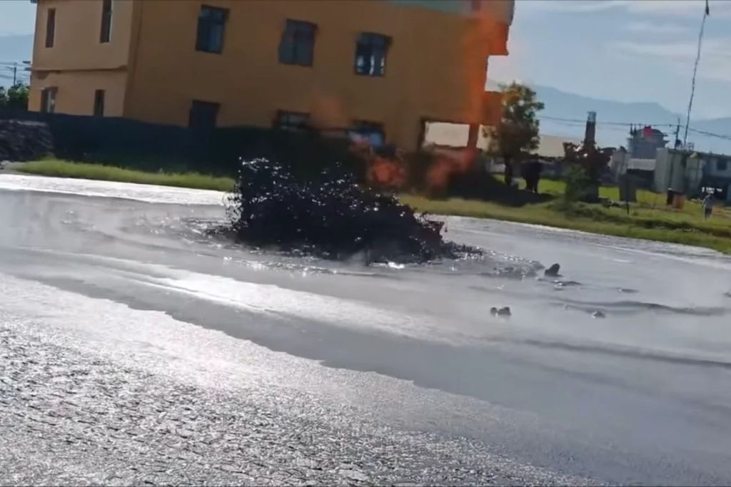 Una de las bocas eruptivas lanza barro ardiente mientras el fuego corona el fenómeno ante la mirada de los vecinos